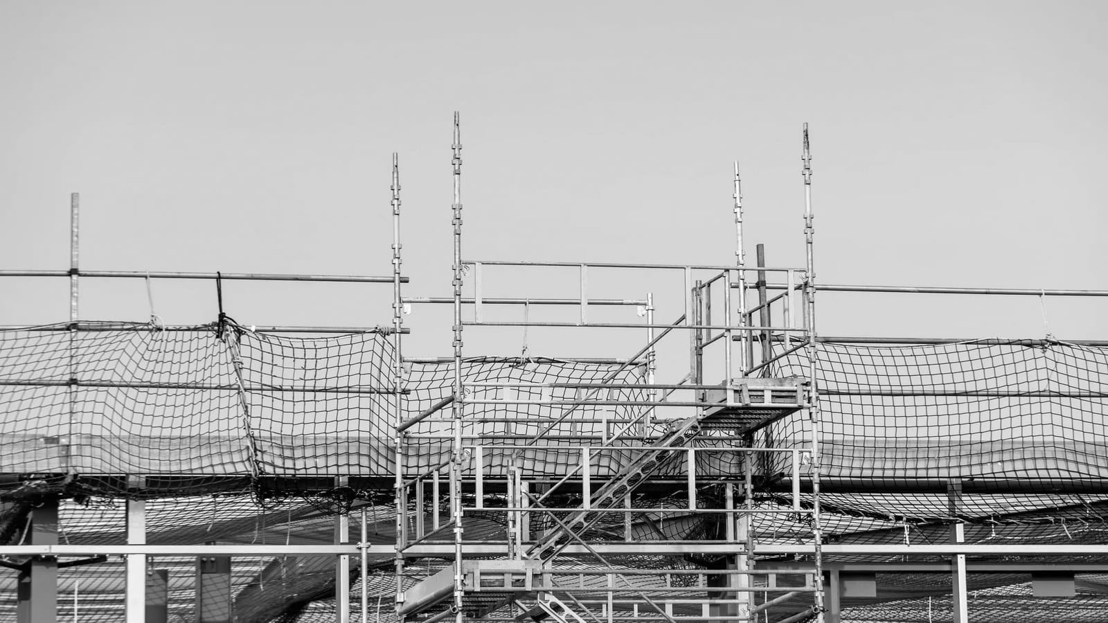 Trabajo en altura sobre un andamio durante la instalación de la techumbre de un galpón industrial.